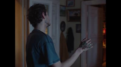  a man holding something in his hand in front of a door