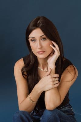 a woman sitting on the ground posing for a picture