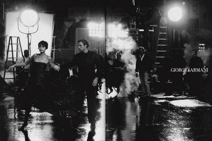 a black and white photo of a man and a woman walking in the rain