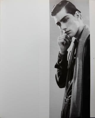 a black and white photo of a man smoking a cigarette