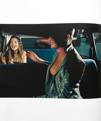 a woman sitting in a car talking to another woman