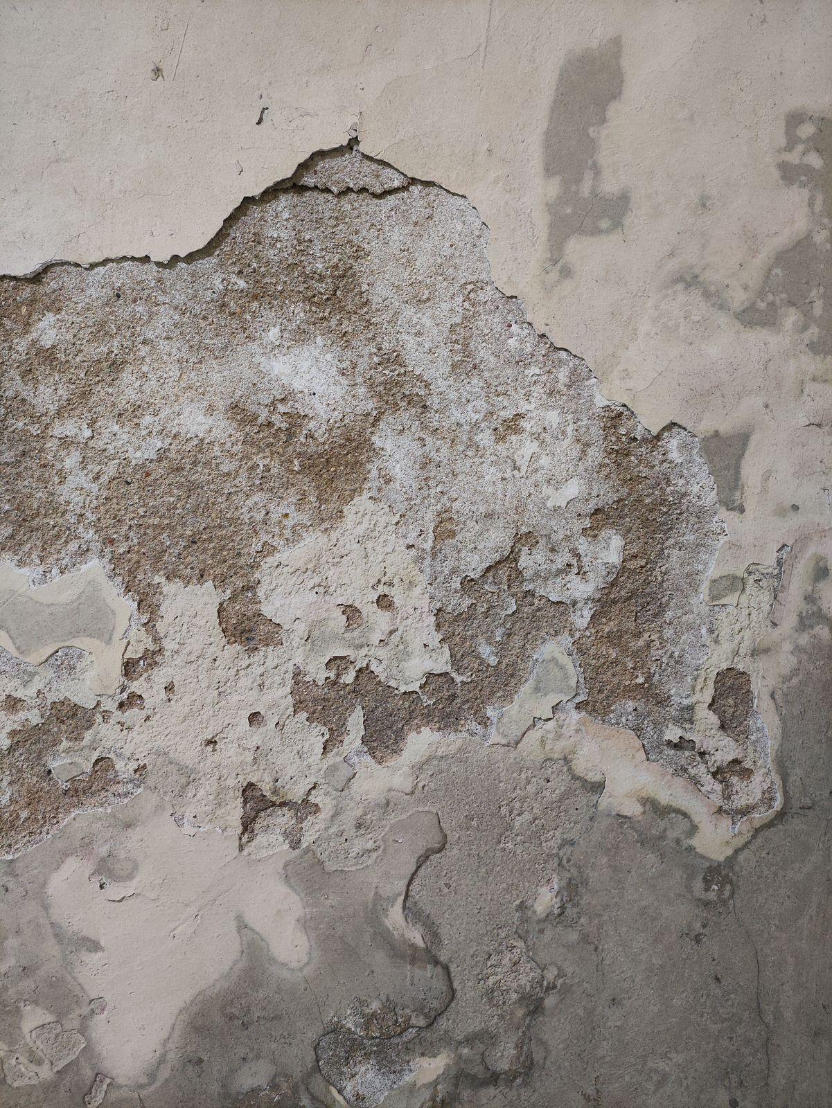 a close up of a wall with peeling paint