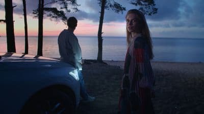 a man and a woman standing next to a car
