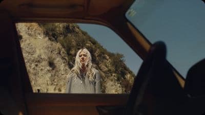 a woman standing in front of a mirror in a car