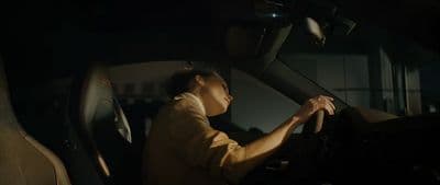 a person sitting in a car with a steering wheel