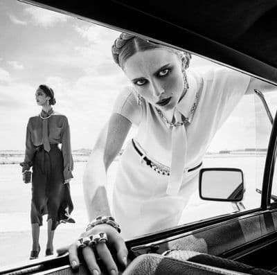 a black and white photo of two women in a car