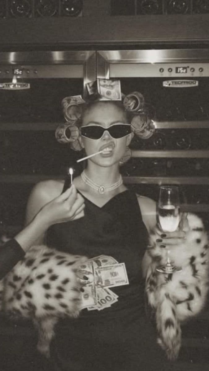 a woman smoking a cigarette and holding a glass of wine