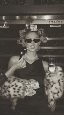 a woman smoking a cigarette and holding a glass of wine