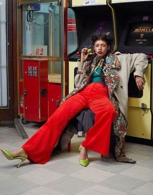 a woman sitting on a bench in front of a bus
