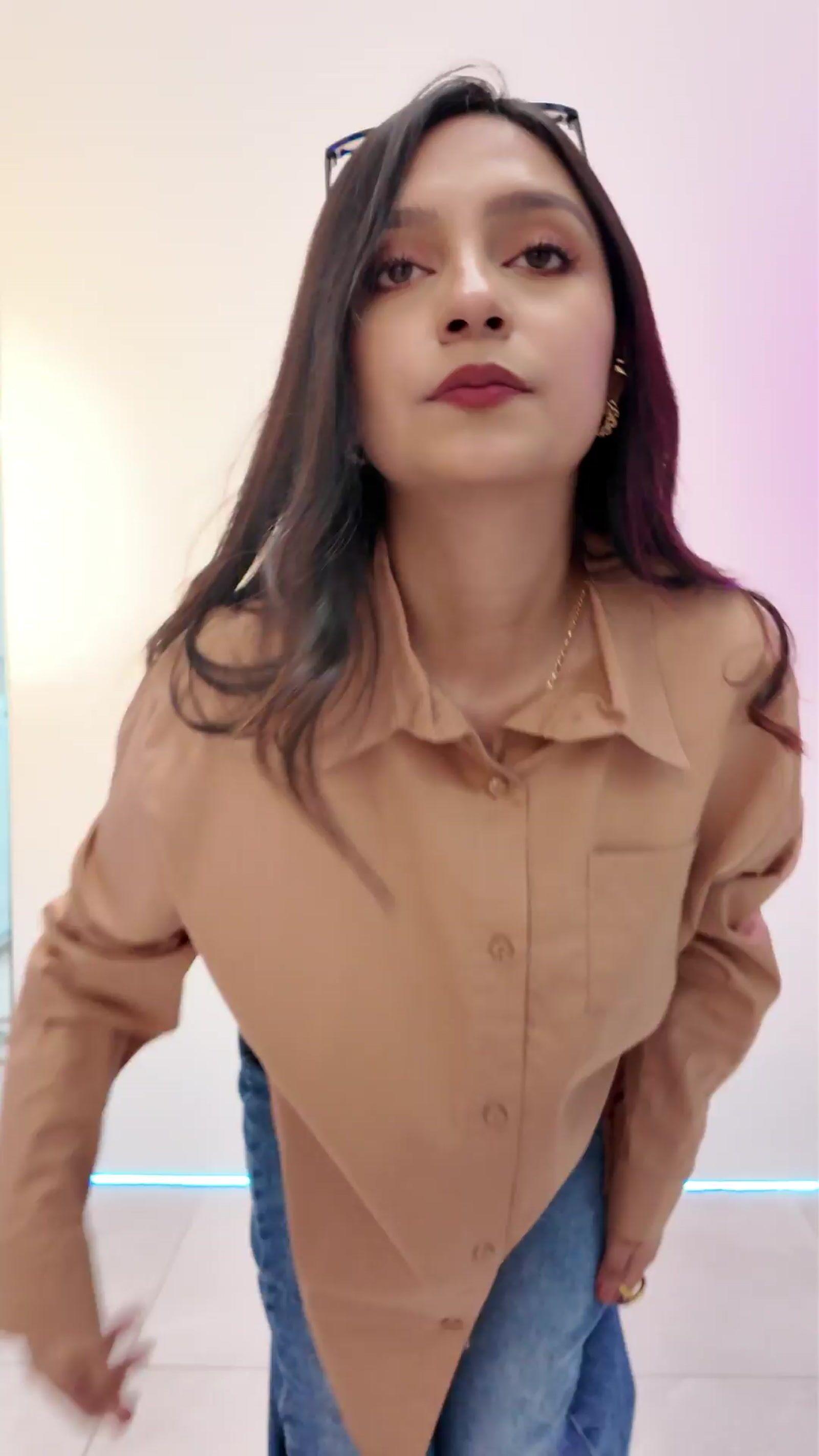 a woman wearing a tan shirt and jeans