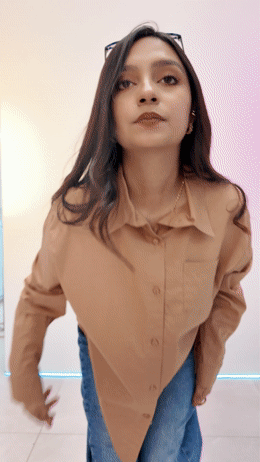 a woman wearing a tan shirt and jeans