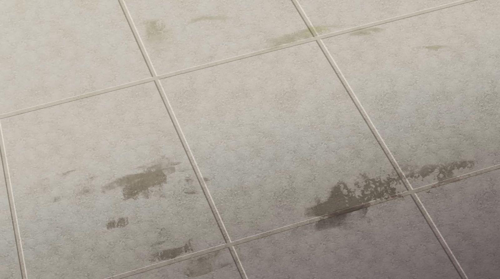 a white tiled floor with brown stains on it