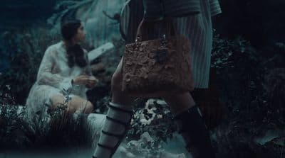 a woman in high heeled boots and a handbag