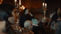 a group of people sitting around a table with candles
