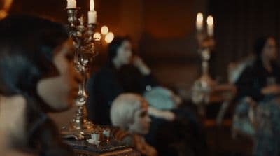 a group of people sitting around a table with candles