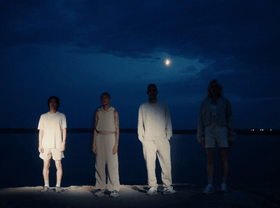 a group of people standing next to each other on a beach