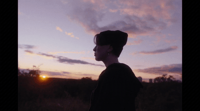 a person standing in front of a sunset