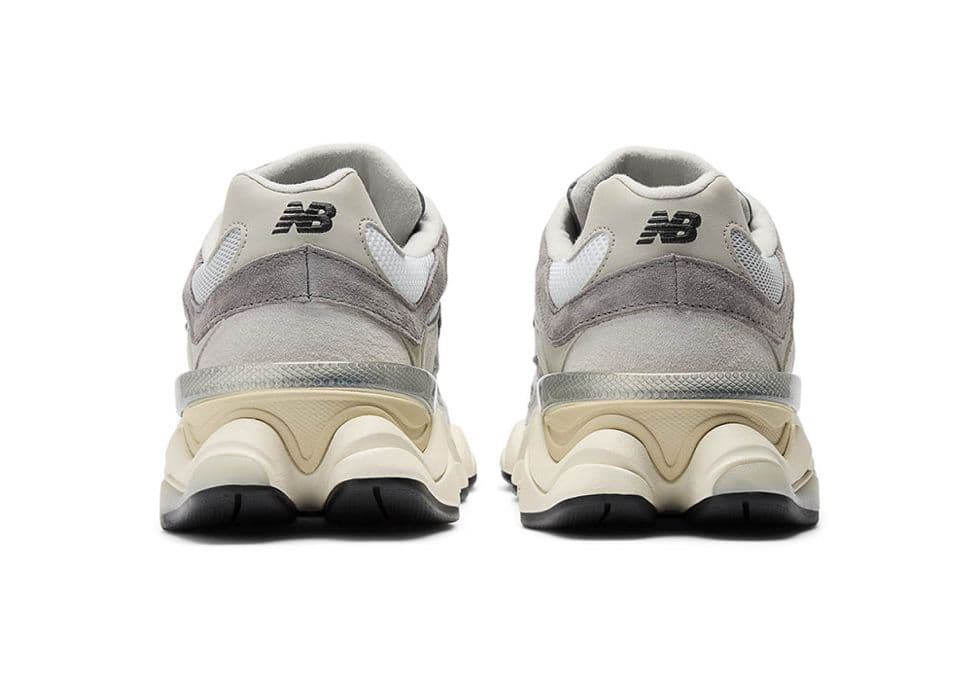 a pair of grey and white sneakers on a white background