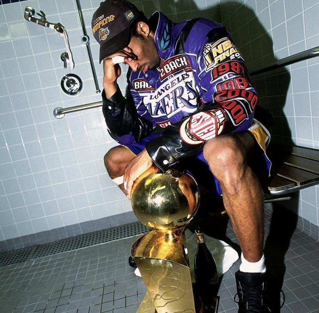 a man sitting on a bench next to a trophy