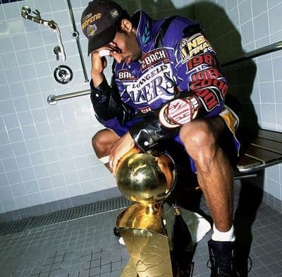 a man sitting on a bench next to a trophy