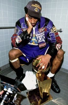 a man sitting on a toilet holding a football