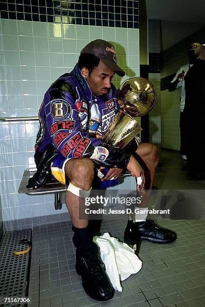a man sitting on a bench holding a trophy