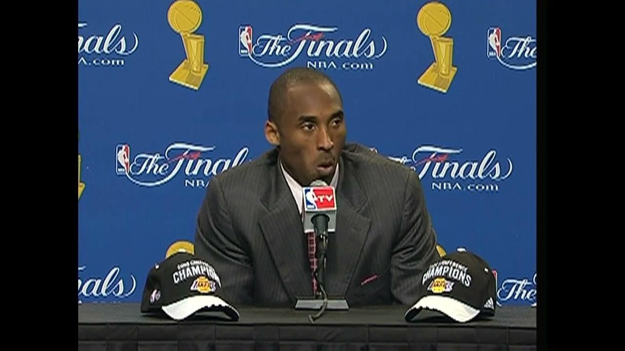 a man sitting in front of a microphone at a press conference