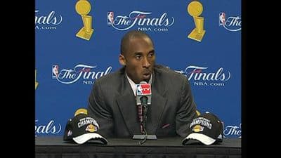 a man sitting in front of a microphone at a press conference