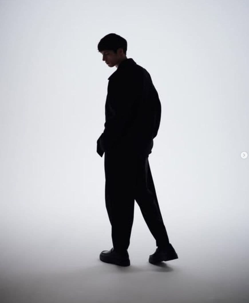 a man standing in the middle of a white room
