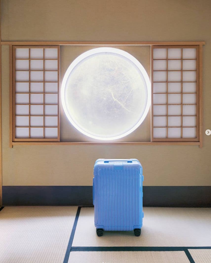 a blue suitcase sitting in front of a window