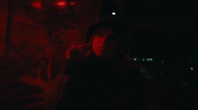 a person standing in a dark room with a red light