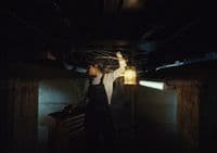 a man holding a light in a dark room