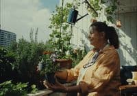a woman sitting on a bench holding a potted plant