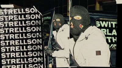 a person wearing a ski mask and holding a pair of skis
