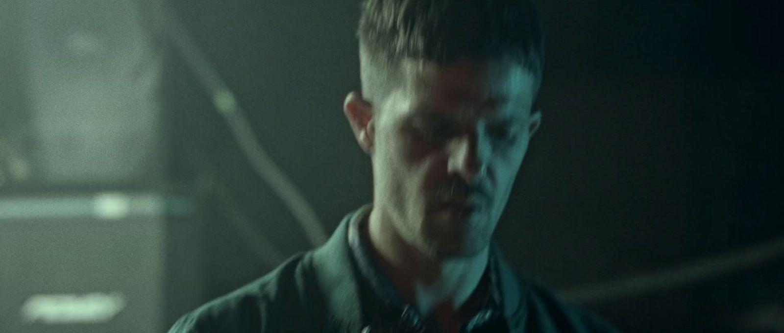 a man standing in a dark room looking at something