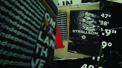 a pile of black and white posters on a wall