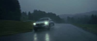 a car driving down a road in the rain