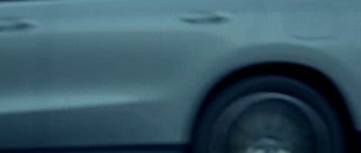 a blurry photo of a white car driving down a street
