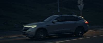 a car driving down a street at night