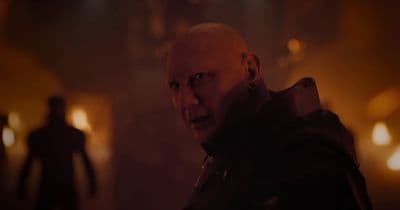 a bald man standing in a dark room