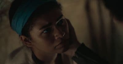 a woman with a blue headband looking at another woman