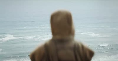 a blurry photo of a person standing in front of a body of water