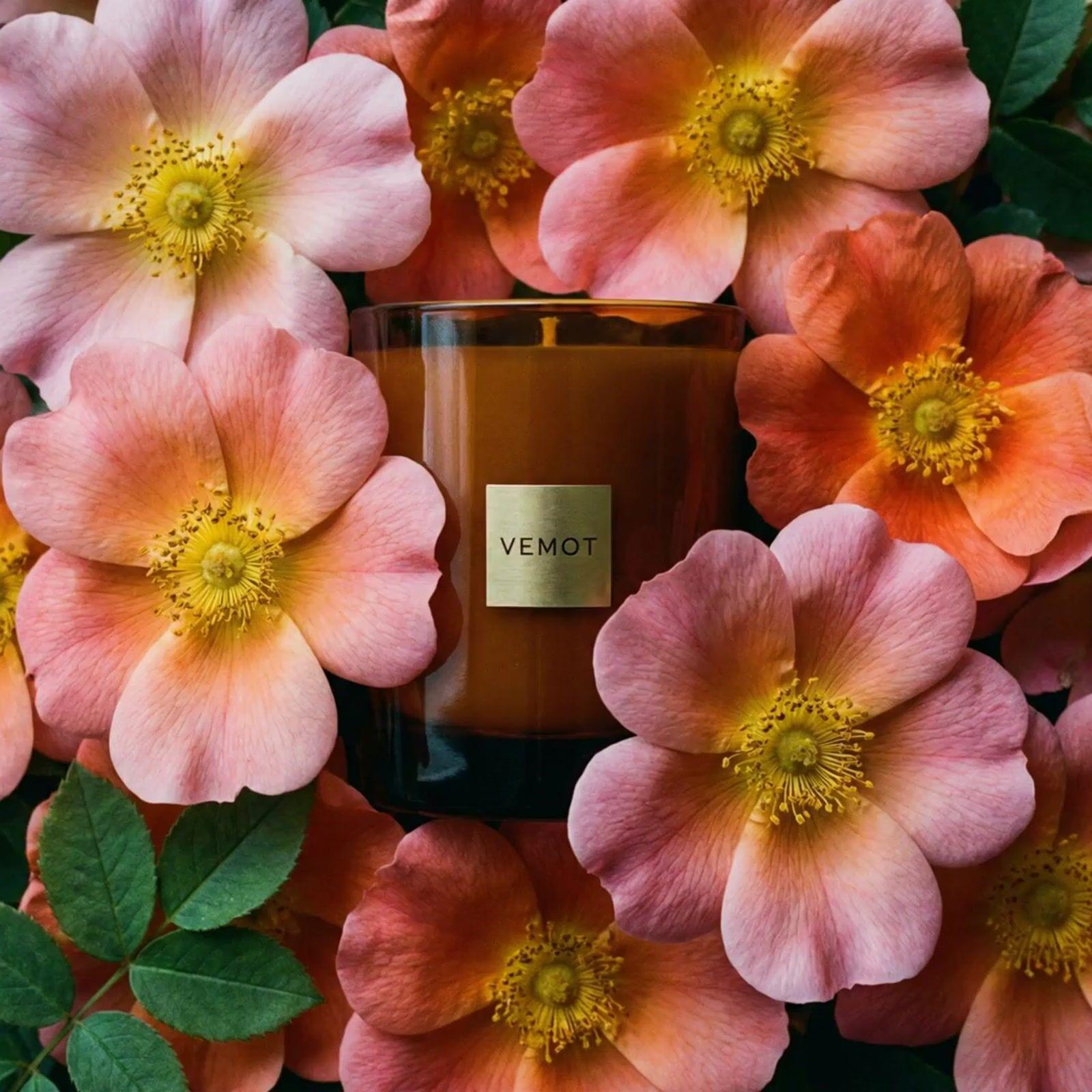 a close up of a candle surrounded by flowers
