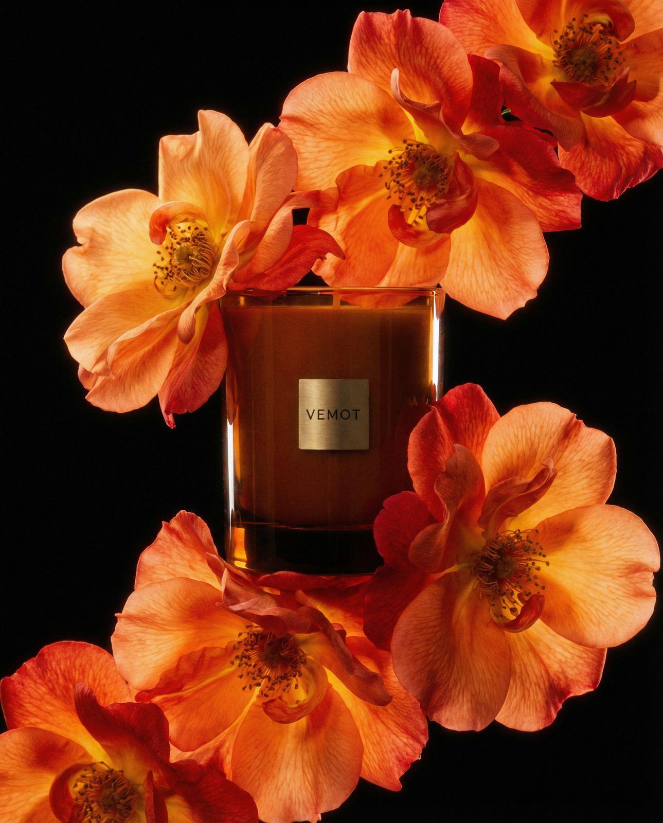 a bottle of perfume surrounded by orange flowers