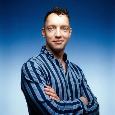 a man with his arms crossed posing for a picture