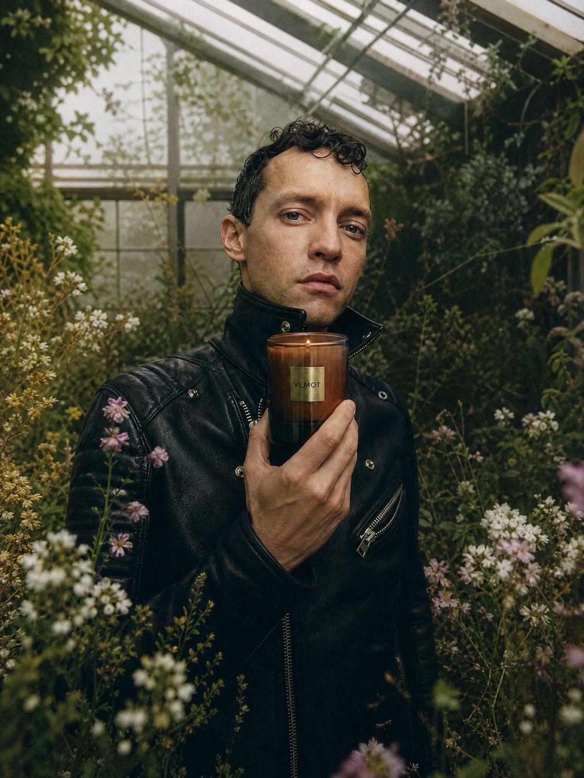 a man holding a cup of coffee in a greenhouse