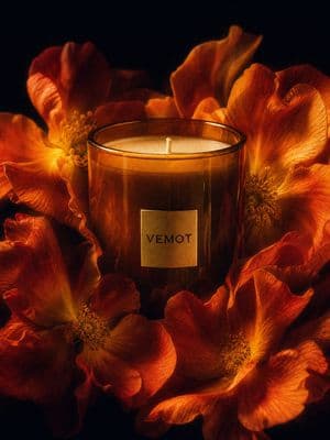 a candle sitting on top of a bunch of flowers