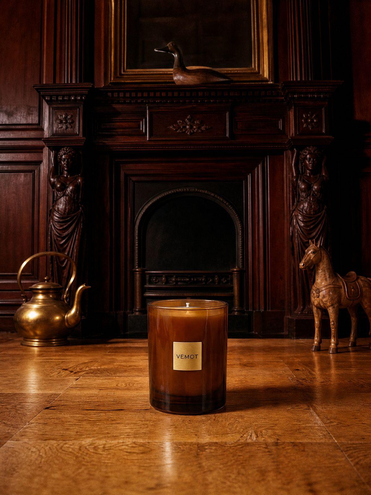 a candle sitting on the floor in front of a fireplace