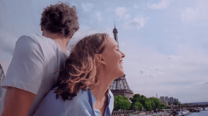 a man and a woman looking at the eiffel tower