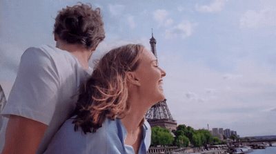 a man and a woman looking at the eiffel tower
